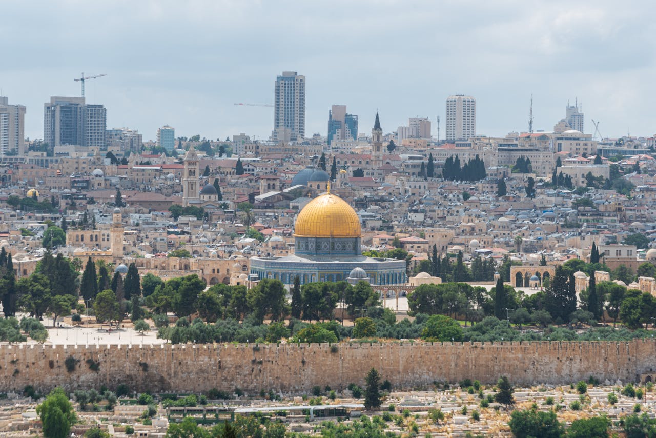 Captivating aerial view of the Dome of the Rock with Jerusalem's skyline in the background.