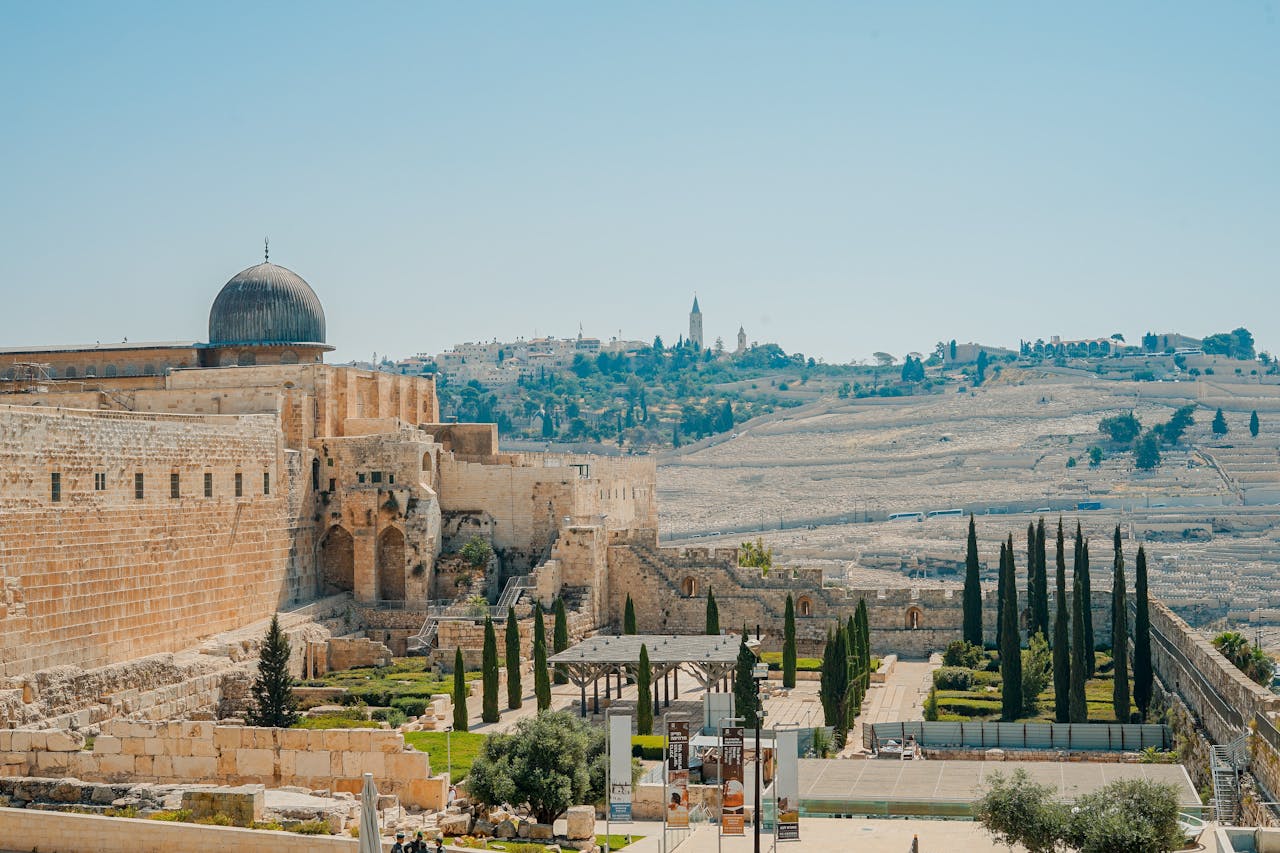 View of the historic Jerusalem walls and Al-Aqsa Mosque with a clear blue sky backdrop.