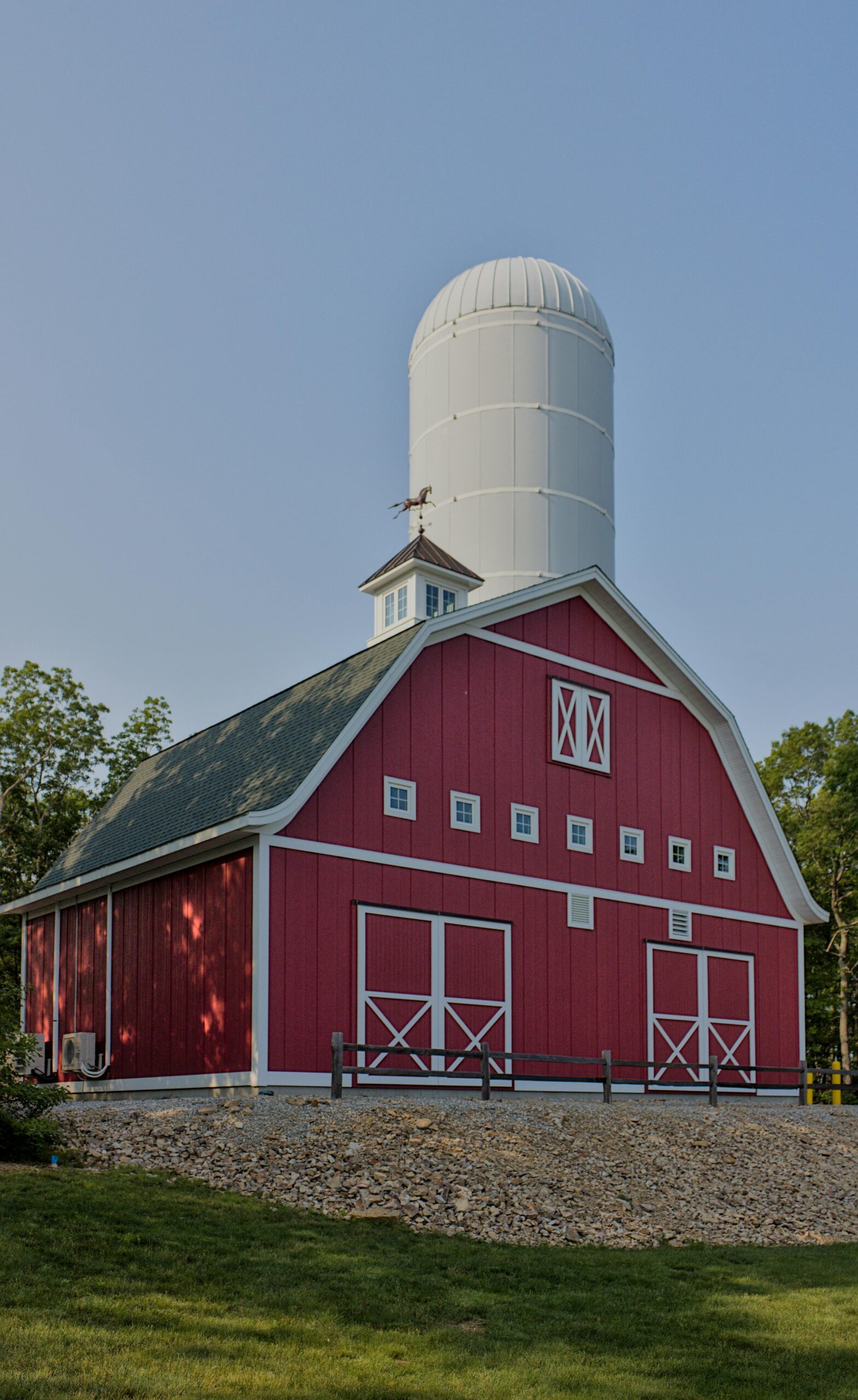 Charming red barn with attached grain silo in a rural landscape. Perfect for agricultural themes.