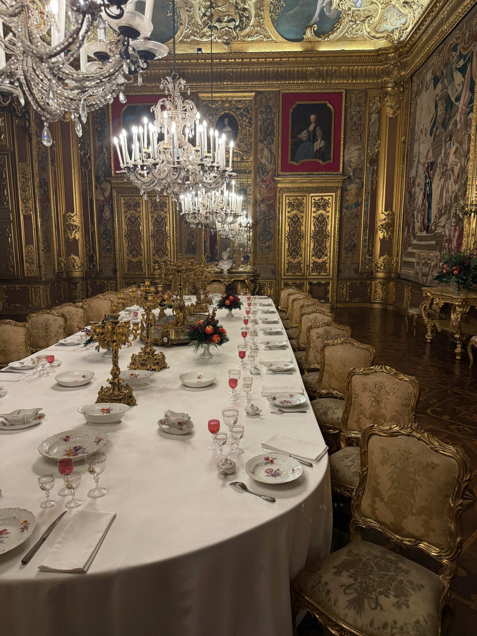Opulent Baroque dining room with elegant chandeliers and lavish decor setting a regal atmosphere.